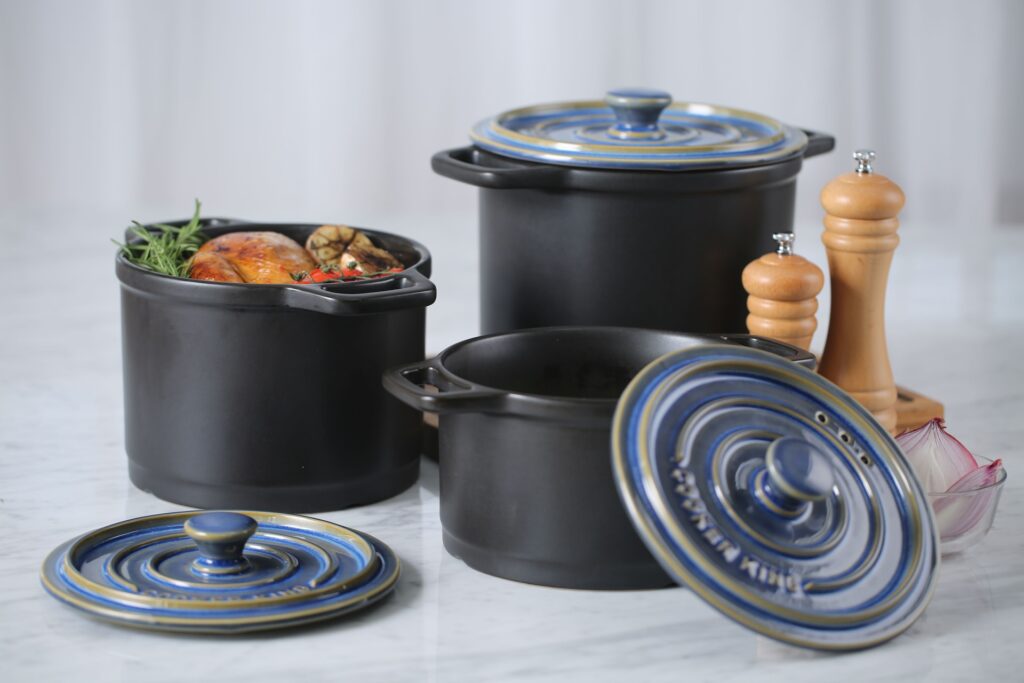 Three large black pots with food in them