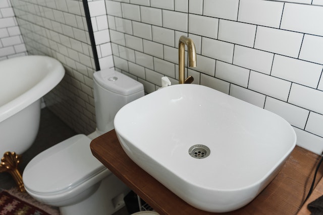 Bathroom with a white sink, toilet, and porcelain tiles