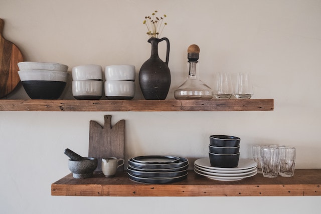 Plates and glasses on brown wooden shelves