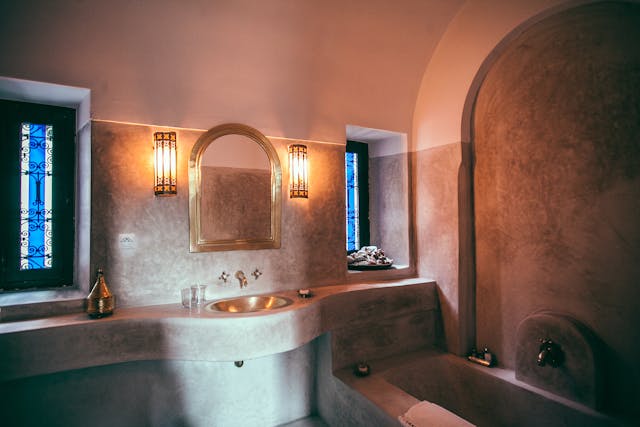 A stone design around a sink, mirror, and a bathtub