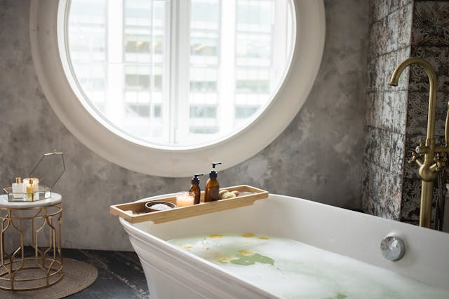 A bathtub full of water underneath a large round window