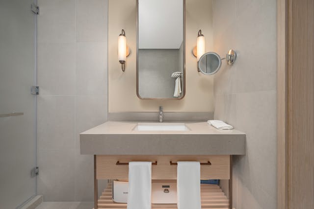 modern bathroom vanity area featuring a rectangular sink with a gray countertop and a wooden cabinet below